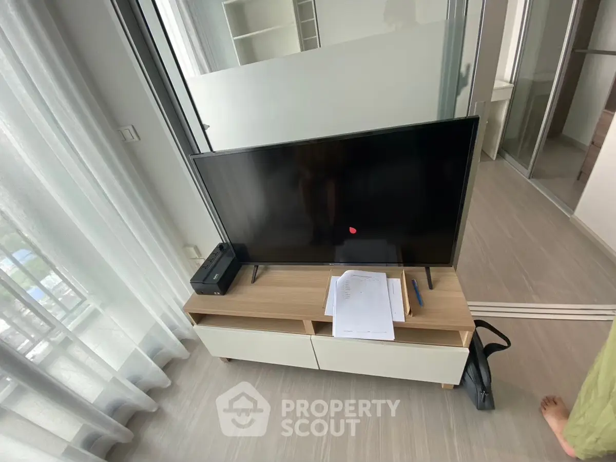 Modern living room with sleek TV setup and natural light