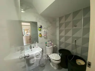 Modern bathroom with geometric tiles and sleek fixtures in a stylish home.