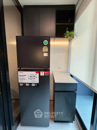 Modern kitchen with sleek black fridge and minimalist cabinetry