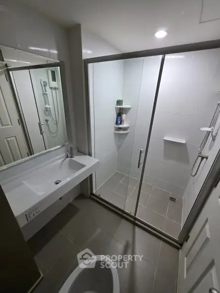 Modern bathroom with glass shower enclosure and sleek fixtures