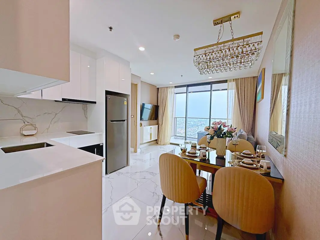 Luxurious open-plan kitchen and dining area with stunning city view, elegant chandelier, and modern appliances.