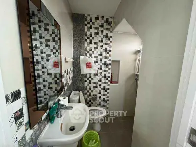Modern bathroom with stylish tile design and compact layout.