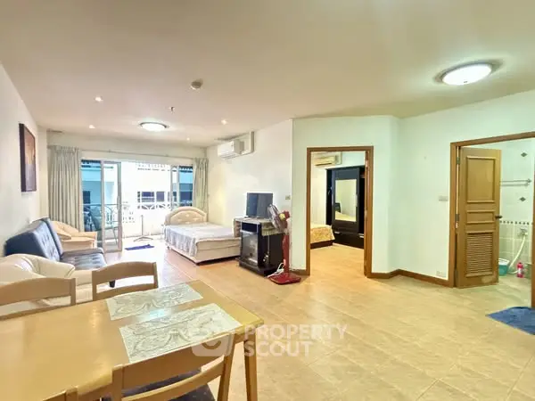 Spacious open-plan living area with modern furnishings and balcony access