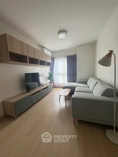 Modern living room with sleek furniture and natural light, perfect for relaxation and entertainment.