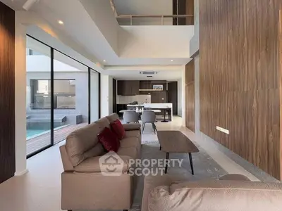 Luxurious modern living room with open layout and pool view, featuring elegant furnishings and stylish decor.