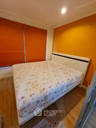 Cozy bedroom with vibrant orange accents and floral bedding