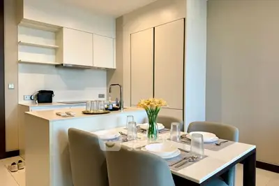 Modern kitchen with dining area featuring sleek cabinetry and elegant table setting.
