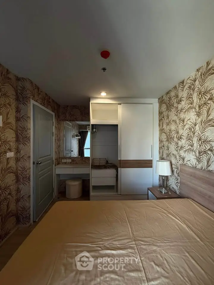 Cozy bedroom with stylish wallpaper and built-in wardrobe, perfect for modern living.