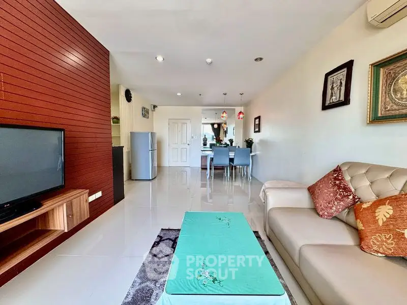Spacious living room with modern decor and dining area in open layout apartment.