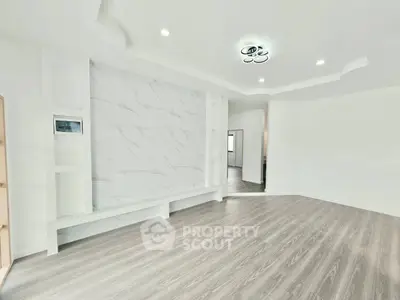 Spacious modern living room with elegant flooring and stylish ceiling lights.