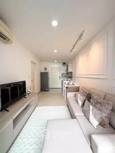 Modern living room with cozy seating and sleek TV unit in a stylish apartment.