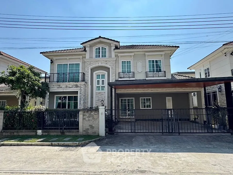 Elegant two-story house with spacious driveway and charming balcony