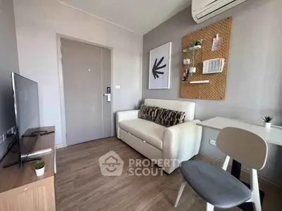Modern living room with stylish decor, featuring a cozy sofa, wall art, and air conditioning.