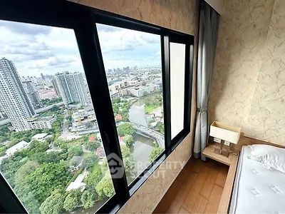 Stunning high-rise bedroom with panoramic city view and large windows.