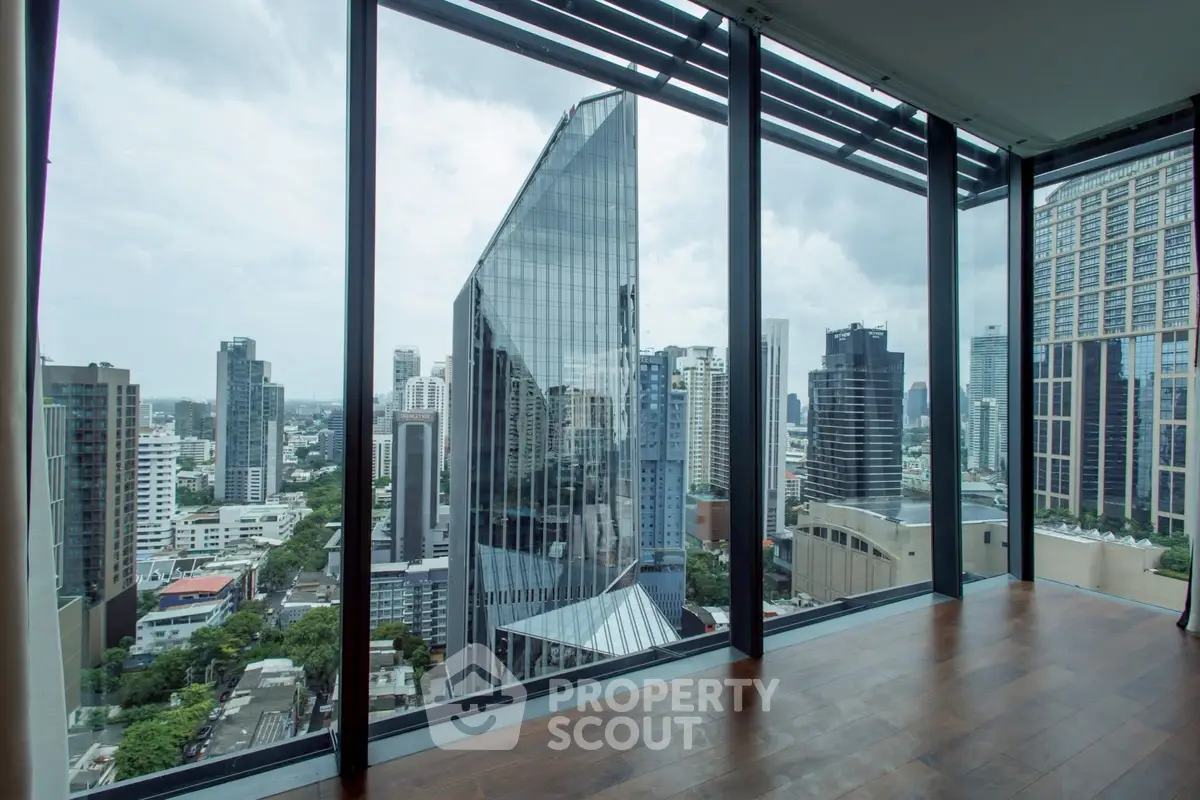 Stunning cityscape view from modern high-rise apartment with floor-to-ceiling windows.