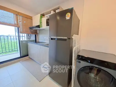 Modern kitchen with sleek appliances and balcony view in a stylish apartment.
