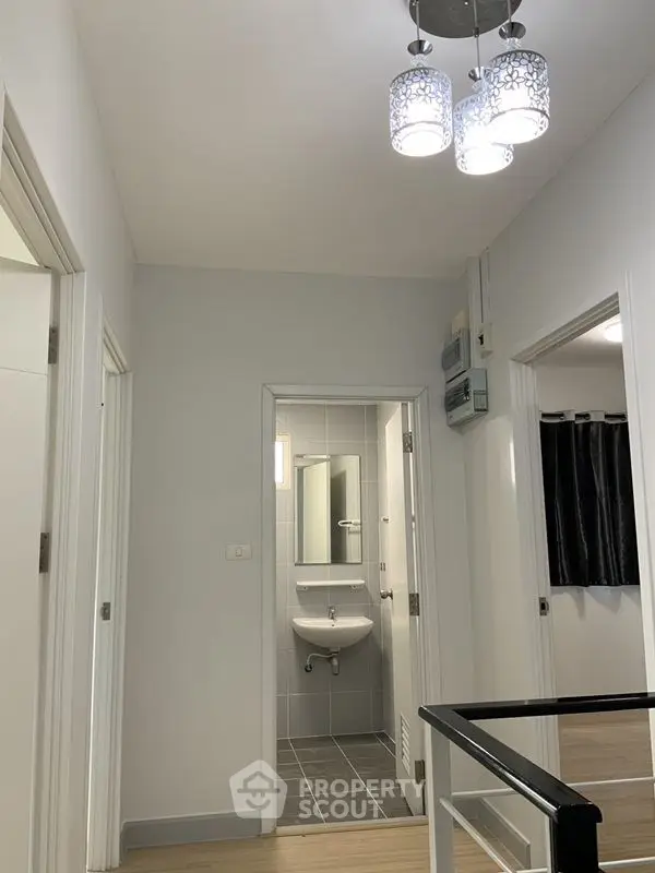 Modern hallway with stylish lighting and view into a sleek bathroom