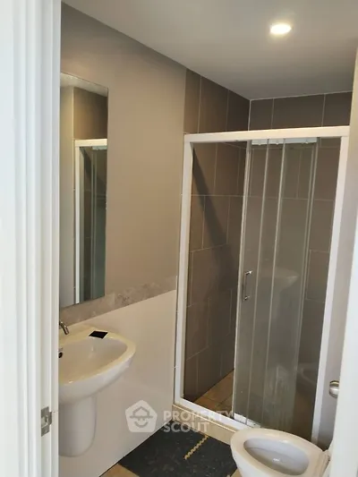 Modern bathroom with sleek shower and contemporary sink design.