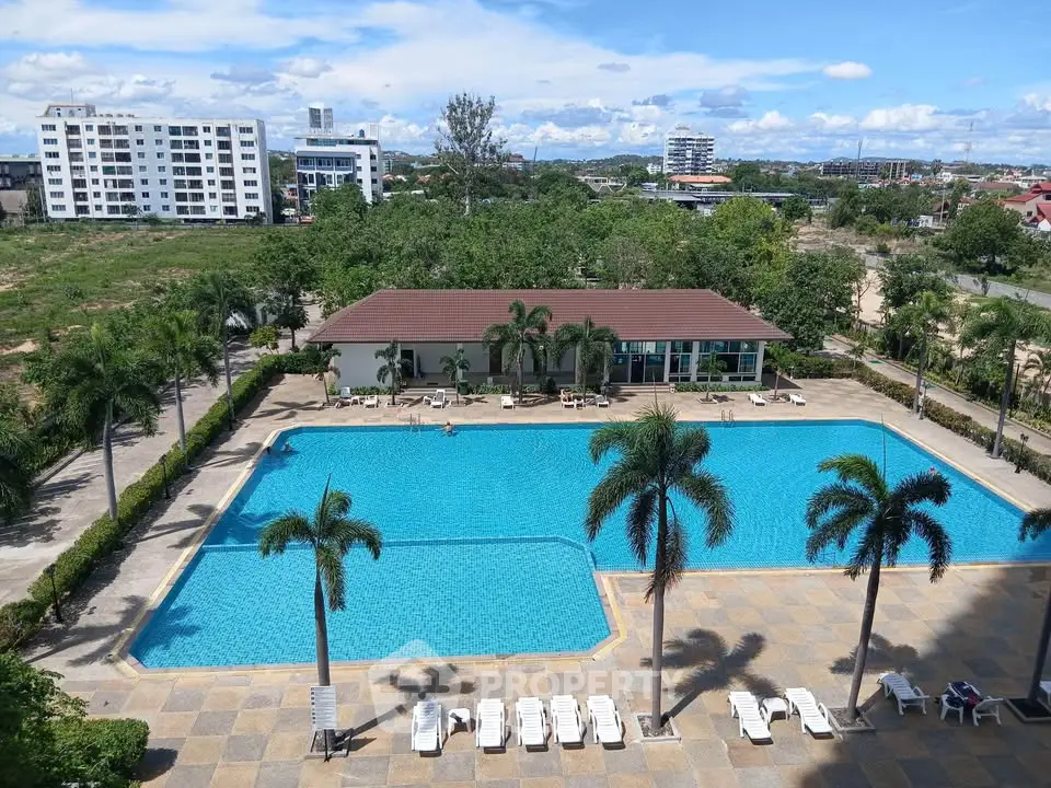 Luxurious apartment complex with a large swimming pool and lush greenery, perfect for relaxation and leisure.