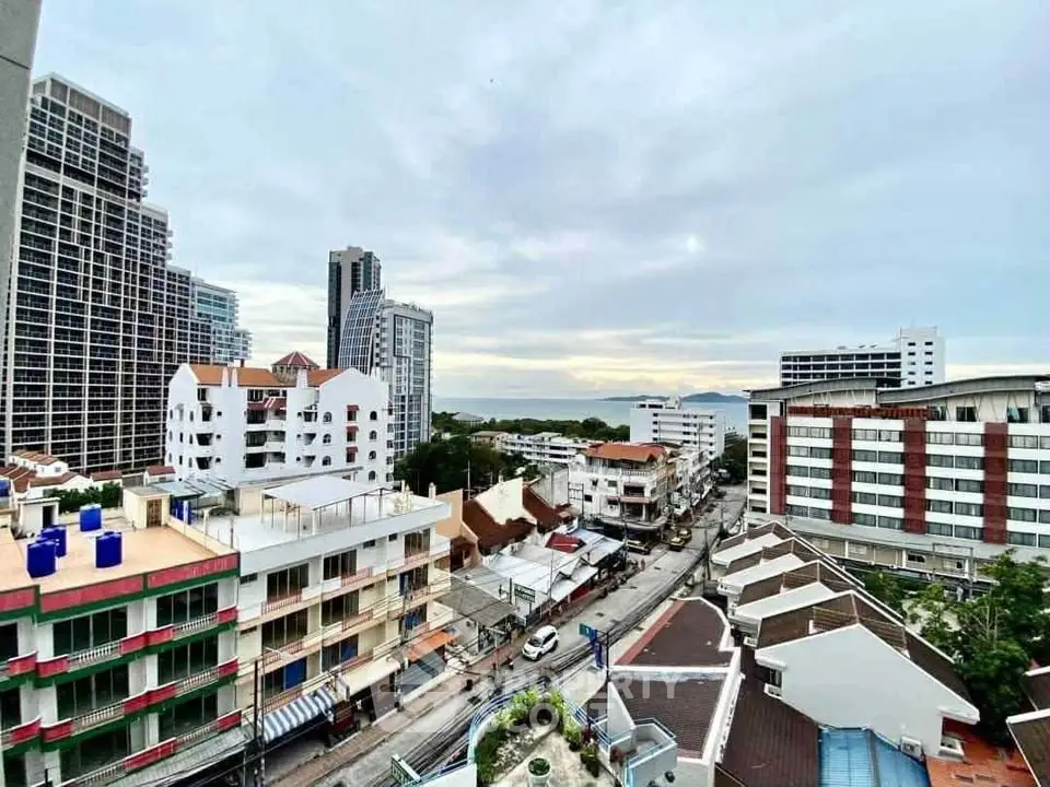 Stunning cityscape view from high-rise balcony overlooking urban skyline and distant sea.