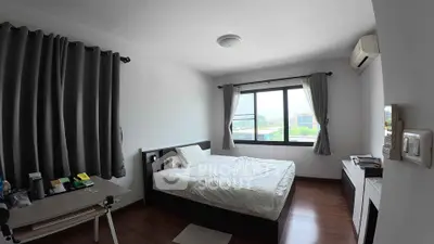 Spacious bedroom with large window and modern furnishings, perfect for comfort and relaxation.
