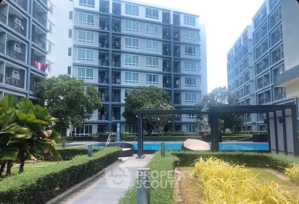 Modern apartment complex with pool and landscaped gardens offering urban living in a serene environment.