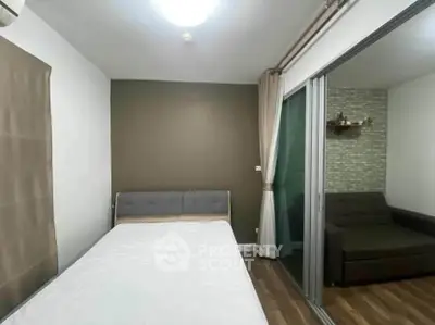 Modern bedroom with sliding glass doors leading to cozy living area, featuring stylish decor and natural light.