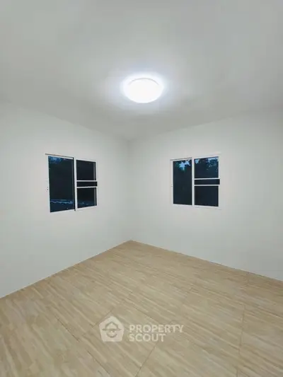 Spacious empty room with tiled flooring and bright lighting