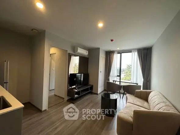 Modern living room with sleek furniture and large windows offering natural light.