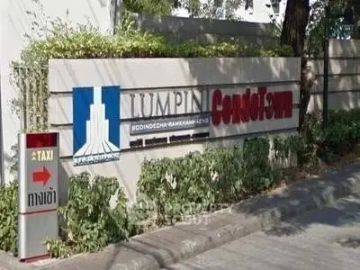 Lumpini Condominium entrance sign with lush greenery and clear pathway.