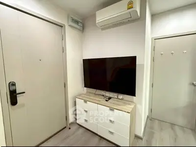 Modern apartment interior with sleek TV setup and air conditioning unit.