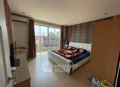 Cozy bedroom with stylish decor and balcony access in modern home.