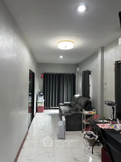 Spacious living room with modern decor and ample natural light, perfect for relaxation and entertainment.