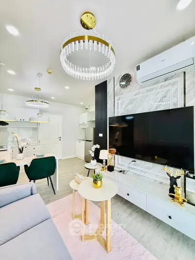 Modern living room with elegant chandeliers, stylish decor, and open kitchen layout.