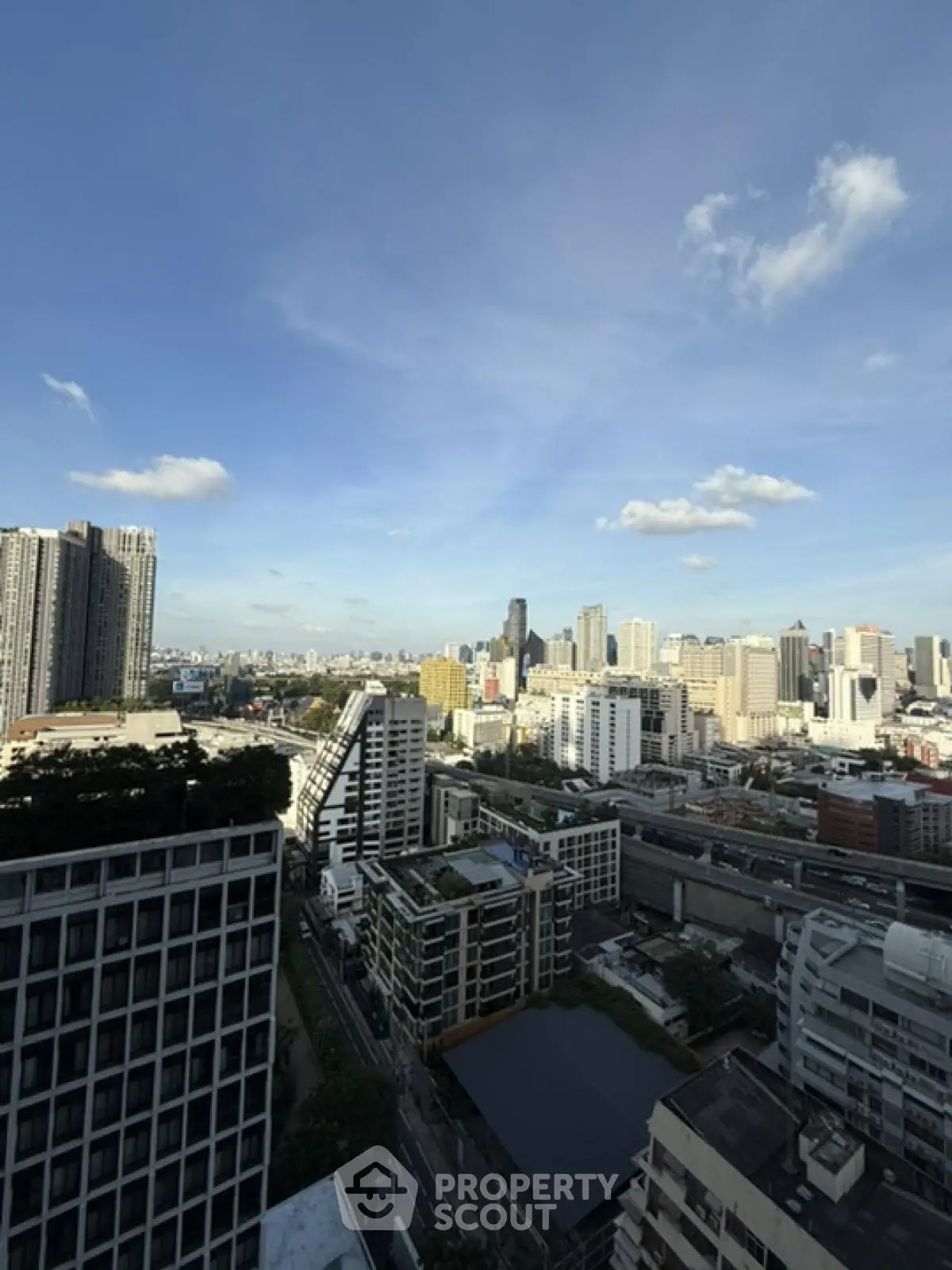 Stunning cityscape view from high-rise building, showcasing urban skyline under clear blue sky.
