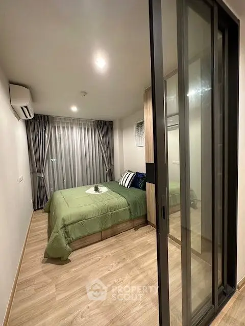 Modern bedroom with sliding glass doors and stylish decor in a cozy apartment.
