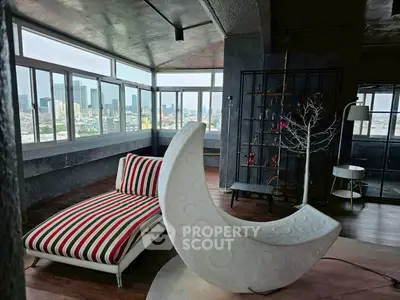 Stylish modern living room with panoramic city views and unique crescent moon chair.