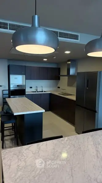 Modern kitchen with sleek design, featuring stainless steel appliances and elegant lighting.