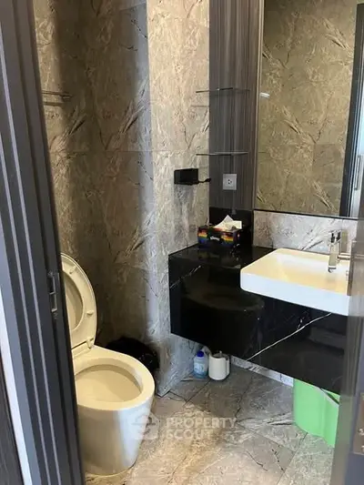 Modern bathroom with sleek marble tiles and contemporary fixtures.