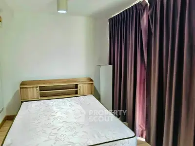 Cozy bedroom with natural light and elegant curtains, perfect for relaxation.