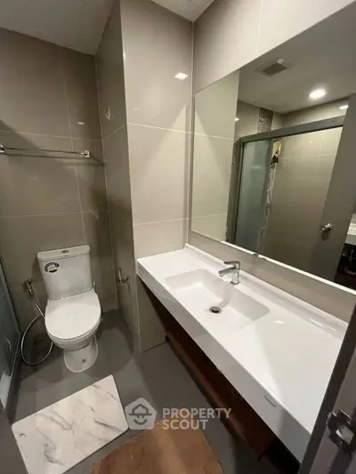 Modern bathroom with sleek fixtures and spacious vanity in contemporary apartment.