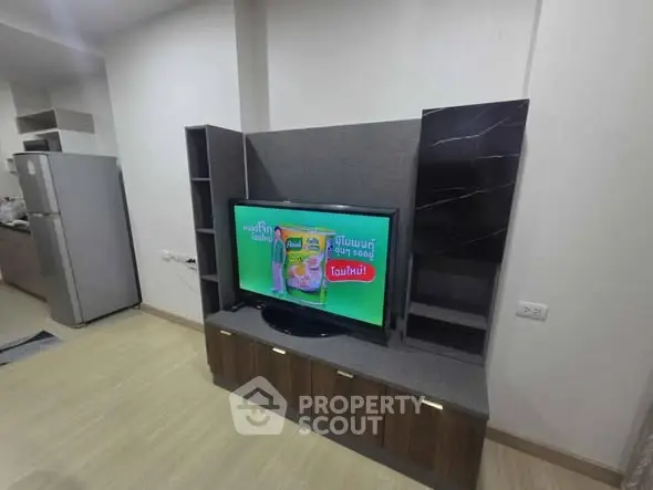 Modern living room with sleek entertainment center and kitchen view