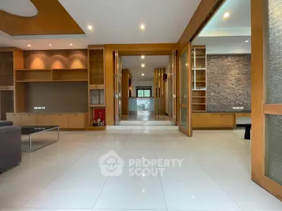 Spacious modern living room with elegant wooden accents and ample natural light.