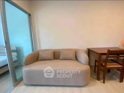 Modern living room with cozy beige sofa and wooden dining set in open layout apartment.