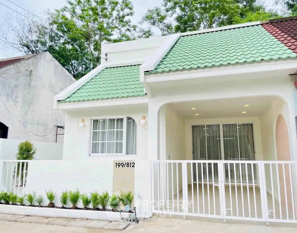 Charming single-story home with green roof and spacious front patio, ideal for modern living.