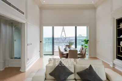 Luxurious living room with stunning river view and elegant dining area, perfect for entertaining.
