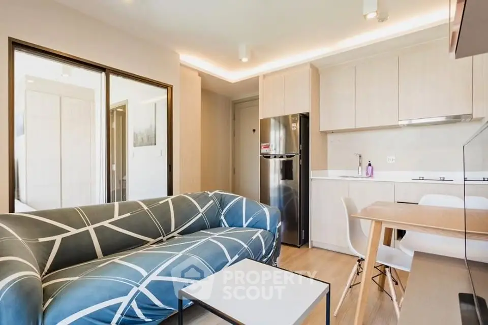 Modern living room with stylish sofa and open kitchen layout in a bright apartment.
