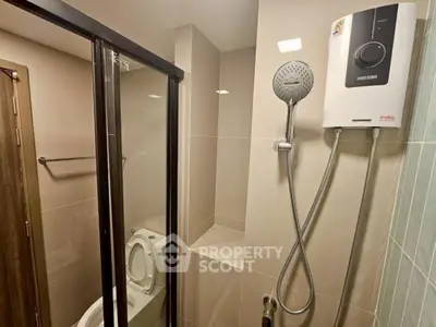 Modern bathroom with sleek shower and water heater in contemporary apartment.
