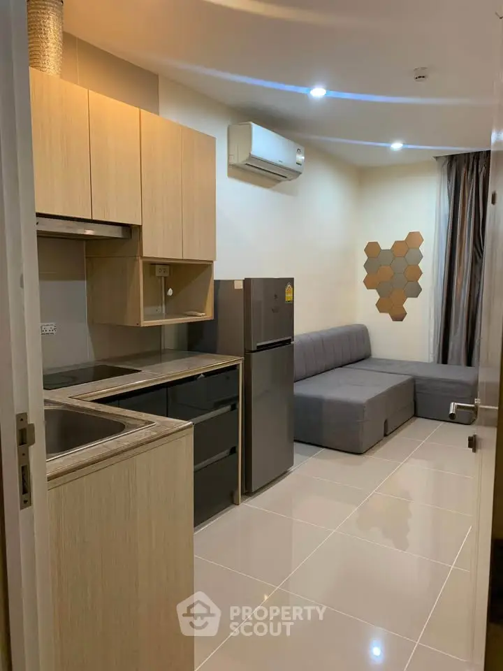 Modern compact kitchen and living area with sleek design and neutral tones.