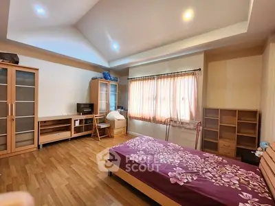 Spacious bedroom with wooden flooring and modern furniture